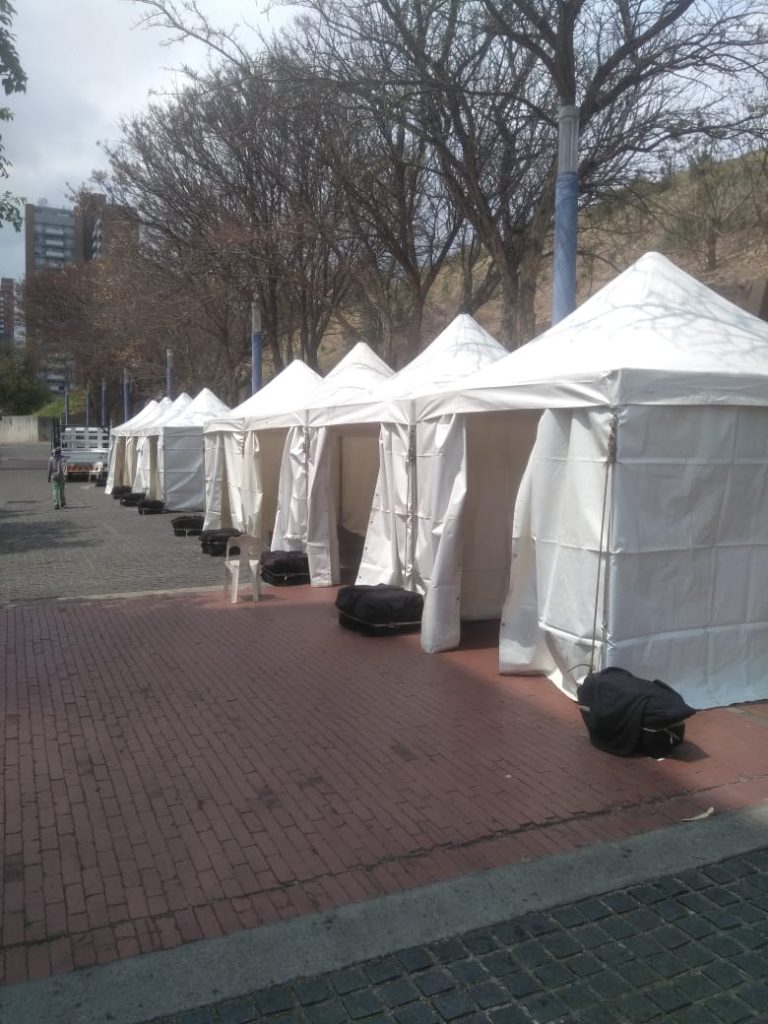 Events Guys A row of white tents for hire lined up on a sidewalk.